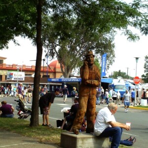 Old man taking a break next to the thinking man "Remember When" wood carving. Canon EOS T3i. Old man taking a break next to the thinking man "Remember When" wood carving. Canon EOS T3i.