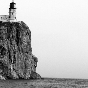 Little girl sits on rocks in the shadow of Split Rock Lighthouse. Canon EOS Rebel T3i. Little girl sits on rocks in the shadow of Split Rock Lighthouse. Canon EOS Rebel T3i.
