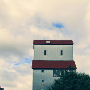 Old grain elevator, built in 1898, rises up against a cloud-filled blue sky. Photography: Stillwater, MN. Old grain elevator, built in 1898, rises up against a cloud-filled blue sky.