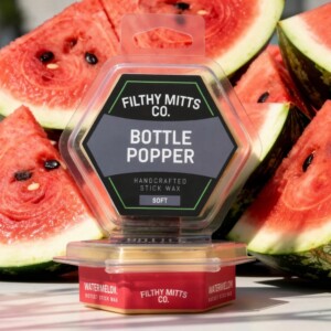 Actual photo of product with updated labeling/packaging processed through Kive.ai to generate realistic themed environment product images. Filthy Mitts Co. Bottle Popper Stick Wax