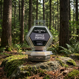 Actual photo of product with updated labeling/packaging processed through Kive.ai to generate realistic themed environment product images. Filthy Mitts Co. Bottle Popper Stick Wax
