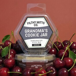 Actual photo of product with updated labeling/packaging processed through Kive.ai to generate realistic themed environment product images. Filthy Mitts Co. Grandma's Cookie Jar Stick Wax
